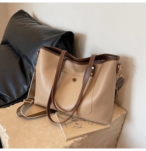 Detail of khaki tote bag with dark brown trim and magnetic pocket on stone background