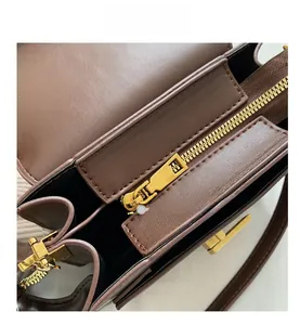 Detail view of smooth golden zipper and premium brown lychee texture leather bag