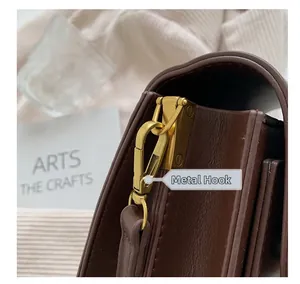 Detailed close-up of premium dark brown leather stitching and matte gold hardware hook