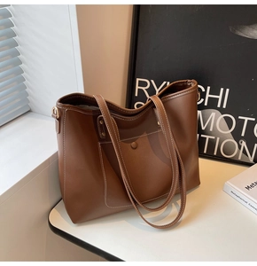 Detail of a brown tote bag with contrast stitching and a front pocket for daily commute