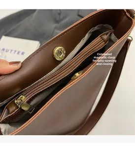 Detail view of large brown shoulder bag featuring hidden magnetic buckle and zipper