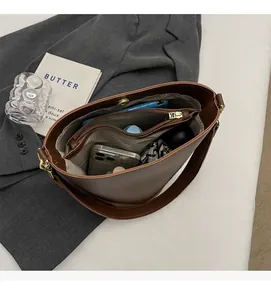 Detailed interior of large brown leather bucket bag showing capacity for daily essentials