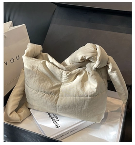Detailed view of an off-white quilted puffer handbag inside a black gift box