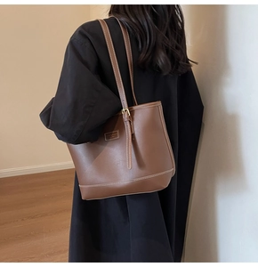 Détail d'un grand cabas en cuir marron foncé avec surpiqûres sur un mannequin
