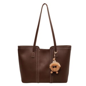 Deep brown leather tote bag with white contrast stitching and cute plush pendant charm