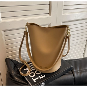 Close-up of khaki bucket bag with golden hardware and adjustable shoulder strap