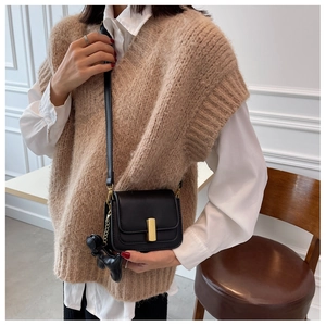 Détails du sac à bandoulière en similicuir noir avec fermoir doré et pendentif
