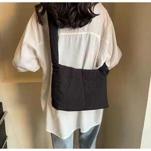 Rear view of a black padded quilted tote bag with wide strap for stylish daily commuting