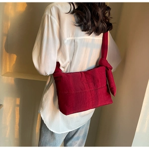 Close-up of wine red quilted tote bag with a stylish knotted bow shoulder strap