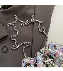 Gros plan d'un sac seau à paillettes colorées avec une chaîne en argent et des plis élégants