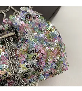 Détail de paillettes colorées et bandoulière chaîne argentée sur un sac seau