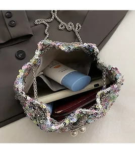Détail de l'intérieur du sac seau à paillettes contenant téléphone et portefeuille