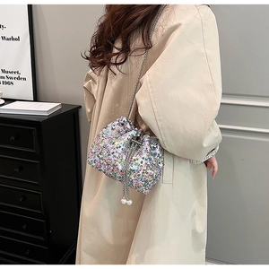Détail du sac seau à paillettes colorées avec cordons en perles blanches et bandoulière chaîne