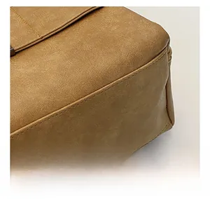 Dettaglio delle cuciture di precisione e trama opaca su borsa in pelle marrone