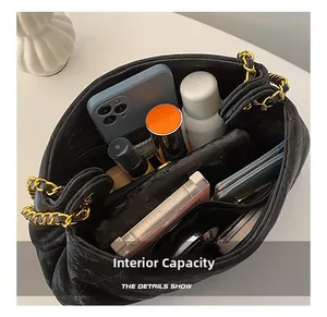 Capacité interne du sac à chaîne noir matelassé avec compartiments pour maquillage et mobile