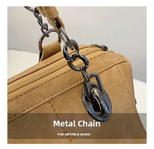 Dettaglio della texture scamosciata marrone con catena in nichel nero e parti metalliche