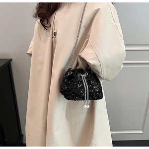 Détail du sac seau noir à paillettes avec chaîne argentée et breloques de perles coulissantes
