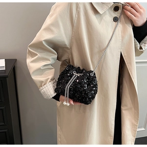Gros plan du sac seau à paillettes noires avec chaîne argentée et détails en perles