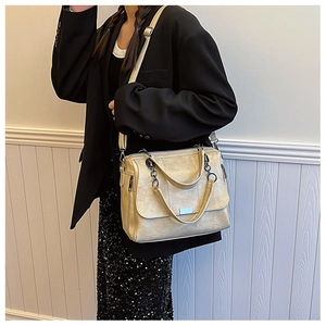 Dettaglio borsa beige texture vintage con catena d'argento e tracolla regolabile