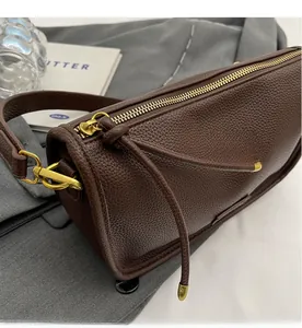 Detail of smooth brass zipper and dark brown lychee leather on Boston bag