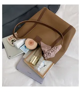 Spacious interior of a brown tote bag showing capacity for tablet and cosmetics