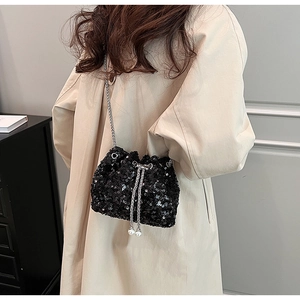 Détail du sac seau à paillettes noires avec cordon perlé et bandoulière chaîne
