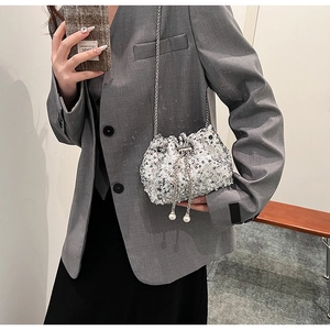 Détail du sac seau à paillettes argentées avec chaîne et breloques en perles