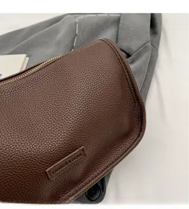 Detailed close-up of dark brown lychee grain leather and metal zipper on Boston bag