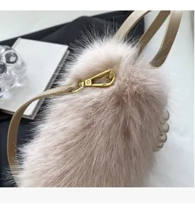Detail der weichen rosa Plüsch-Tasche mit Perlengriff und goldenen Metallschnallen