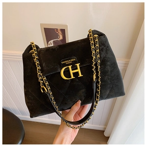 Détail du sac en velours noir matelassé avec fermoir CH doré et bandoulière chaîne