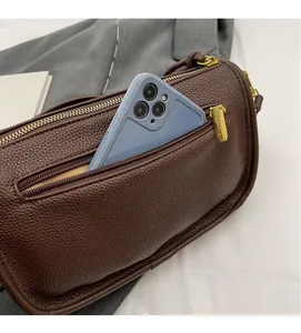 Close-up of front zipper pocket on brown leather Boston bag showing phone capacity