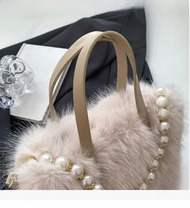 Detail der flauschigen Beuteltasche mit edlem Perlenbesatz und glatten Ledergriffen