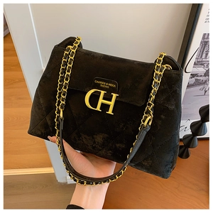 Détail du sac bandoulière en daim noir matelassé avec logo CH doré et bandoulière chaîne