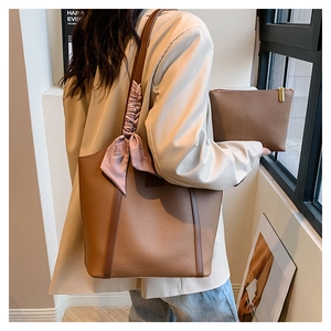 Brown lychee leather tote bag with silk scarf and small pouch shown on a model