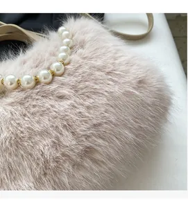 Detailansicht der weichen Kunstpelztextur und des eleganten Perlengriffs einer Plüschtasche
