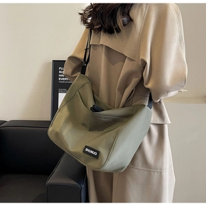 Detailed close-up of large military green nylon tote bag with soft pleated texture