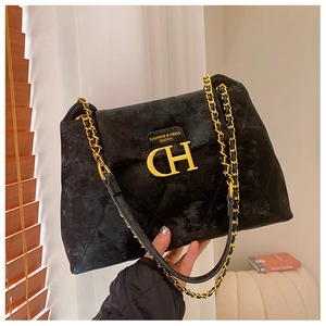 Détail du sac bandoulière en velours noir avec logo CH doré et surpiqûres losanges