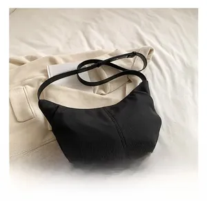 Detail of black corduroy hobo bag showing vertical texture and adjustable strap