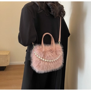 Rosa Plüschtasche mit Perlenkette als Umhängetasche auf einem schwarzen Blazer