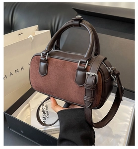 Detail of dark brown leather Boston bag with matte stitching and metallic adjustable strap