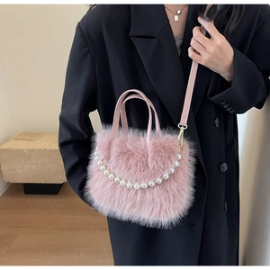 Detailansicht der rosa flauschigen Beuteltasche mit eleganter Perlenkette und goldener Hardware