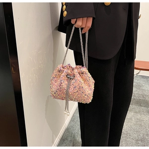 Gros plan du mini sac seau à paillettes roses avec chaîne et détails de perles blanches