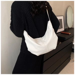 Rear view of model wearing a white crescent shoulder bag with a textured finish