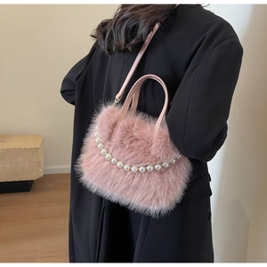 Detail der rosa Kunstpelz-Handtasche mit eleganten weißen Perlenketten und Doppelgriffen