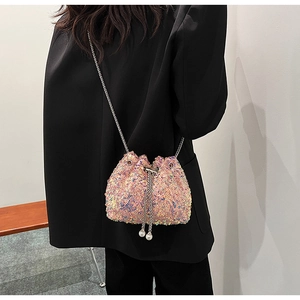 Détail du sac seau à paillettes roses avec cordon, chaîne en métal et pendentif perle