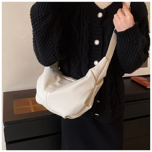 Detailed close-up of the beige corduroy textured fabric on a minimalist half-moon bag