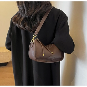 Detail of dark coffee litchi grain leather texture and gold hardware on Boston bag
