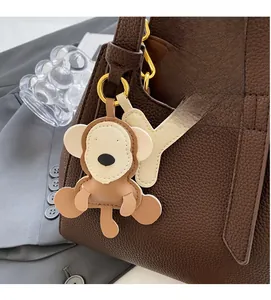 Detail of leather monkey and Y charm on bucket bag with premium gold hardware buckle