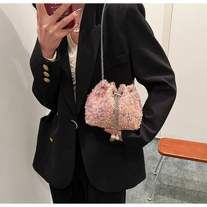 Détail du sac seau à paillettes roses avec chaîne dorée et fermoir cordon perlé élégant