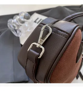 Detailed close-up of dark brown leather handbag with premium silver hardware buckle